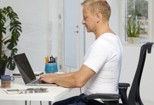 Mies Posture Shirt -paidassa tekee töitä istuen